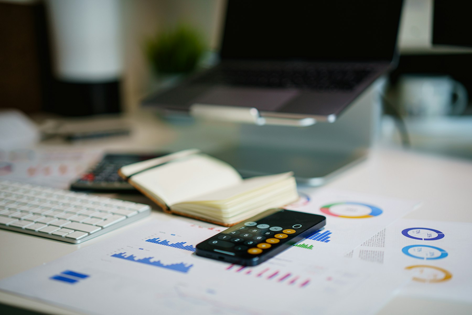 A financial report, calculator and laptop on a desk